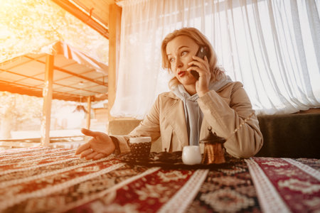 Woman Talking on Phone at a Cafeの写真素材