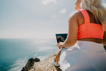 Woman Working on Laptop with Ocean Viewの写真素材