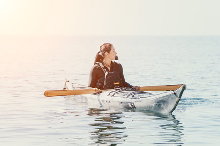 Kayaking Woman Water Sports - Woman in a kayak on the water, enjoying a peaceful morning paddle.の写真素材