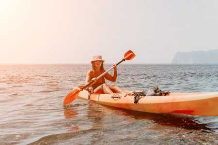 Kayaking Woman Sea - Woman in a kayak paddling on the sea with a scenic view.の写真素材