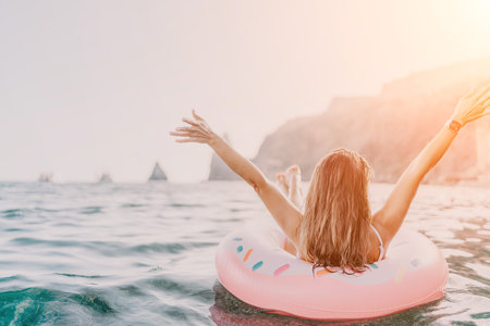 Woman, floating, sea, enjoying serene vacation on inflatable ring with copy spaceの写真素材