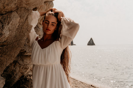 Woman White Dress Ocean Cliffside Photography - Portrait of a woman in a white dress standing near a cliffside overlooking the ocean.の写真素材