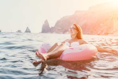 Woman, Ocean, Copy space. Young woman floats on donut ring in sea, enjoying a relaxing summer vacation with ample text space.の写真素材
