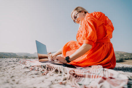 Young Woman Working on Laptop in Natureの写真素材