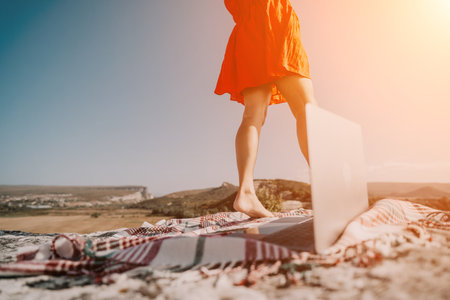 Laptop on the Cliffside Blanket with Womans Feetの写真素材