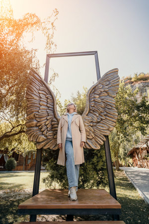 Woman Posing Underneath Wings with a Frame
