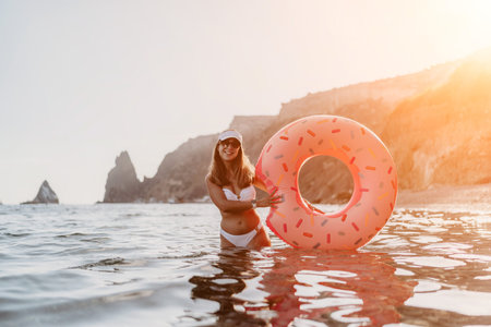 Woman, Donut, Ocean. Happy young woman enjoys summer vacation with inflatable ring on beach, copy...
