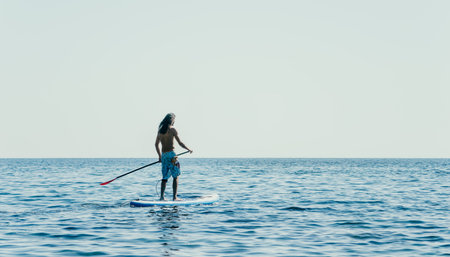 Man Sup Sea. Strong athletic man learns to paddle sup standing on board in open sea ocean on sunny...