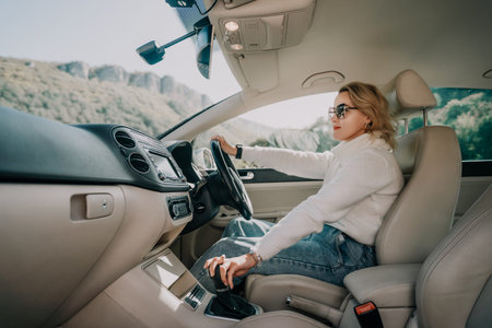 Woman Driving on a Sunny Day with Mountain Viewsの写真素材