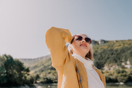 Woman in Yellow Jacket, Looking Up at the Mountainsの写真素材