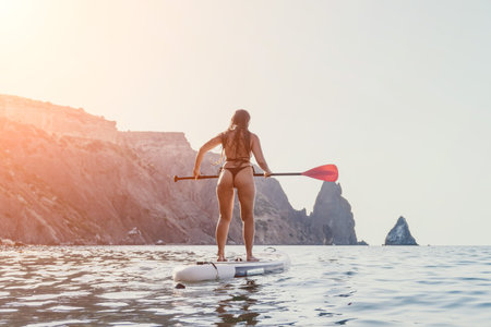 Woman Paddleboarding Ocean Cliffside Seascapeの写真素材