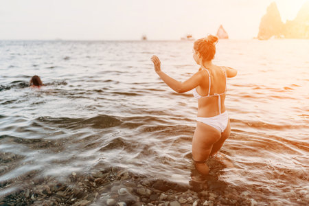 Woman, beach, ocean. Woman in white bikini standing in shallow water enjoying summer vacation at...