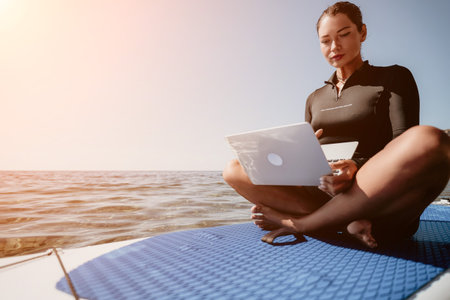 Woman Laptop Ocean - Working on laptop while sitting on a boat on a sunny day.