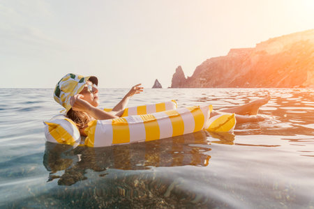 Woman Inflatable Raft Sea Relaxation - Woman floating on a yellow and white inflatable raft in the...