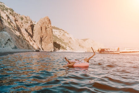Woman, floating, ocean. Young female enjoys a relaxing summer vacation on an inflatable ring near...