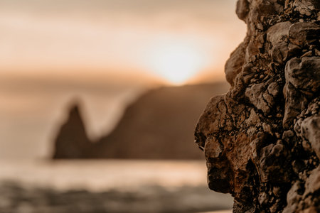 Sunset rock cliff view with close-up texture and soft golden light reflecting on the distant ocean...