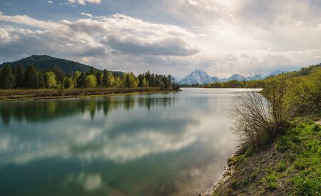 Grand Tetons reflected in still water of the Snake River at Oxbow Bend.の写真素材