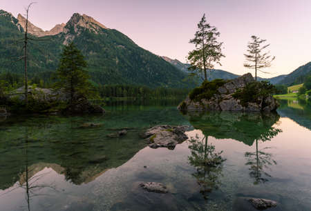 Beautiful scene of trees on a rock island and mountains at sunset time in summer, Lake Hintersee National park Berchtesgadener Land, Upper Bavaria, Germany, Europeの写真素材