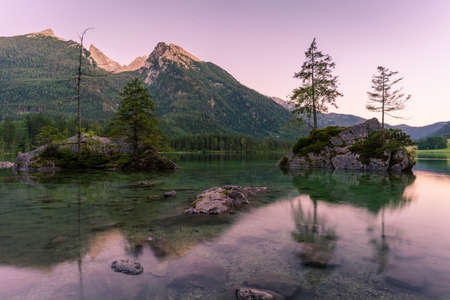 Beautiful scene of trees on a rock island and mountains at sunset time in summer, Lake Hintersee National park Berchtesgadener Land, Upper Bavaria, Germany, Europeの写真素材
