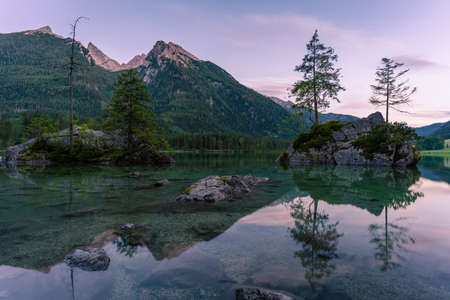 Beautiful scene of trees on a rock island and mountains at sunset time in summer, Lake Hintersee National park Berchtesgadener Land, Upper Bavaria, Germany, Europeの写真素材