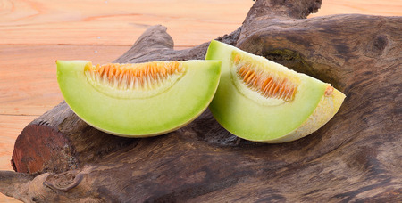Cantaloupe two pieces on wooden floor.の写真素材
