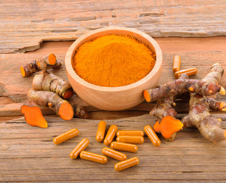 Yellow turmeric on wooden floorの写真素材