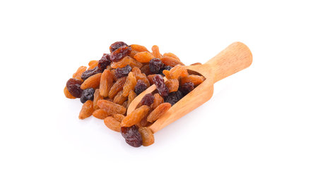 dried raisins in spoon isolated on white backgroundの写真素材