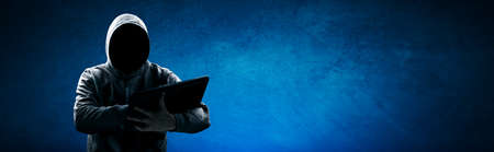 Hacker prints a code on a laptop keyboard to break into a cyberspaceの写真素材