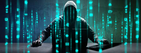 Hacker prints a code on a laptop keyboard to break into a cyberspaceの写真素材