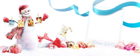 Happy snowman standing in winter christmas landscape.の写真素材