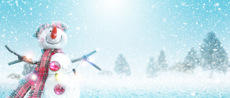 Happy snowman standing in winter christmas landscape.の写真素材