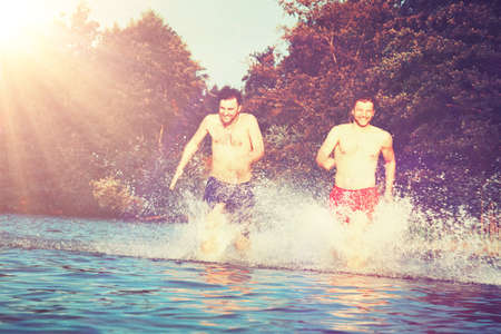 Group of young people playing games on sandy beach on a summer day.の写真素材