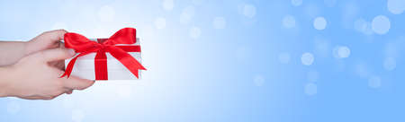 Gift box in wrapping paper with satin ribbon. Merry Christmas holiday concept.の写真素材