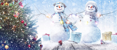 Happy snowman standing in winter christmas landscape.の写真素材