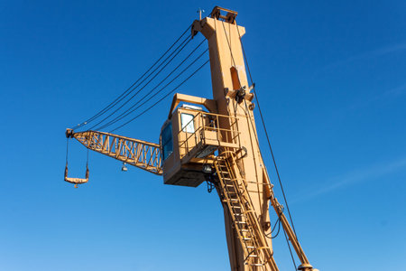 Crane in harbor on blue sky under sunlight