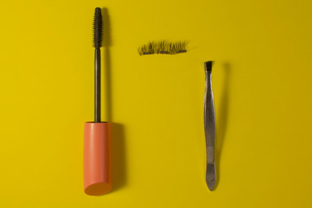 Set of cosmetics for the care of eyelashes on a yellow background.の写真素材