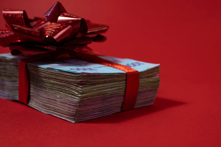 Bundles of new design banknotes drain on a red background including . Money concept. Bundle of money...