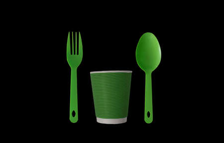 Green spoon, fork and paper cup isolated black background. Disposable eco-friendly tableware made from recycled natural material on a black background or on a table. Food industry. Environmental concept.の写真素材