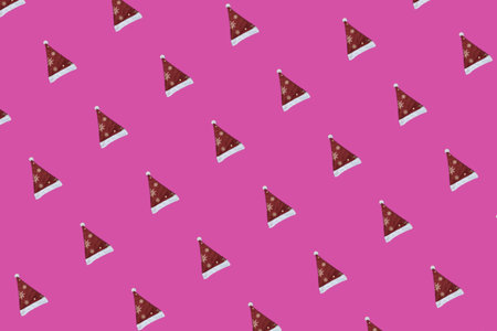 Pattern of Red and White Christmas Santa Claus Hat on a Pink Background. A Repeating Pattern. Happy...
