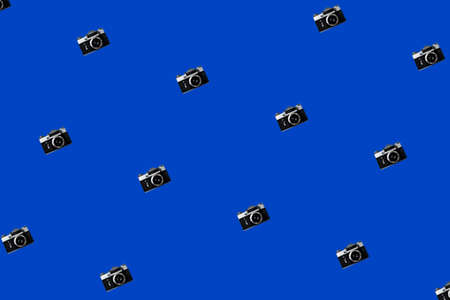 Seamless Pattern With Vintage Iinstant Camera on a Blue Background. Repeating Old Retro Analog Camera on a Colored Background.の写真素材