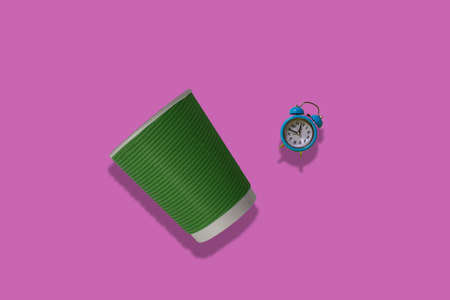 Notepad with coffee and an alarm clock on a pink background. Morning concept.の写真素材