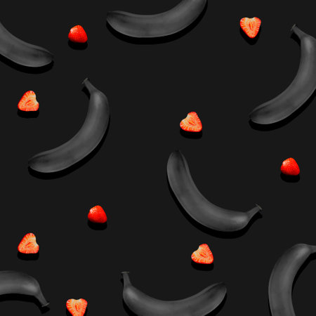 Black Painted Bananas and Strawberries, a Pattern on a Dark Gray Background. concept background. view from above.の写真素材