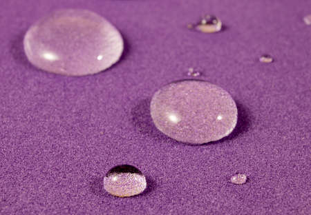 Fantastic and Beautiful Macro Photo of Water Droplets on Purple Background. Beautiful Transparent Rainwater Drops, Macro, Copy Space. Bright Colorful Art Image of Nature. concept of nature.の写真素材