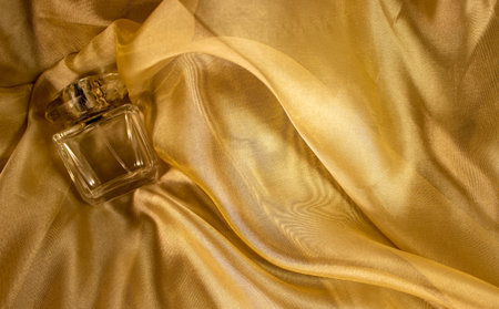 Women's Perfume on Light Golden Background Fabric. Abstract Background Luxurious Fabric, Wavy Pleats...