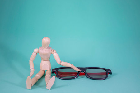 Wood Man and Glasses. The Wooden Figure Sits and Looks Sadly at Glasses for Good Vision. Eye Health...