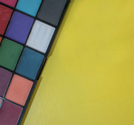 Composition with Eyeshadows on a Yellow Background. Colorful Shadows, Creative Abstract Design Background Photo. Eyeshadow Palette Background.の写真素材
