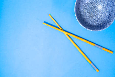 Sushi Chopsticks with Soy Sauce Plates on a Blue Background Copy Space. Japanese Chopsticks for Sushi and a Bowl for Soy Sauce on a Background of Blue Light Stone. View from above. Free Space for Your Text.の写真素材