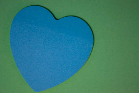 Paper Heart Background, Blue Paper Heart on Green with shadow, on a Colored Background for Love Words. Valentine's Day Concept for Design.の写真素材