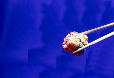 Close Shot Fresh Sushi. Japanese food. Baked (hot) Sushi with Fish and Cheese on Sticks on a Blue Background, with Copy Space. Traditional Japanese Sushi, Delicious Food.の写真素材