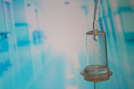Selective Focus on Drip System with Medical Solution Drop. Intravenous Drip System on a Blue Hospital Background. Hospital Drop Counter on a Light Background, Treatment, Medical Equipment. health concept.の写真素材